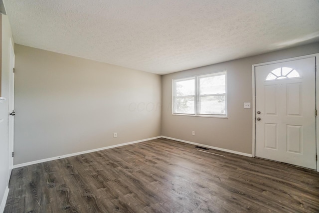 entryway featuring a textured ceiling, baseboards, and dark wood-type flooring