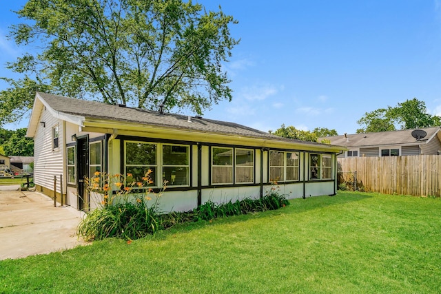 back of house with a yard, a sunroom, and fence