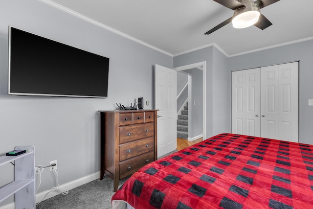 carpeted bedroom featuring baseboards, ceiling fan, a closet, and crown molding