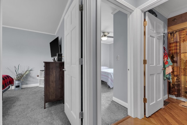 hallway with baseboards, carpet flooring, and crown molding
