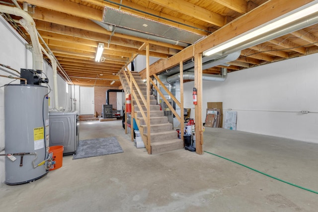 unfinished below grade area featuring stairs, water heater, and washer / clothes dryer