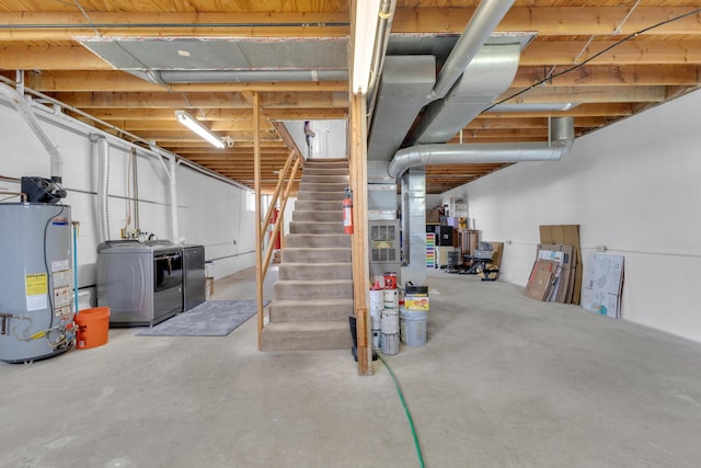unfinished basement with gas water heater, washer and clothes dryer, and stairway