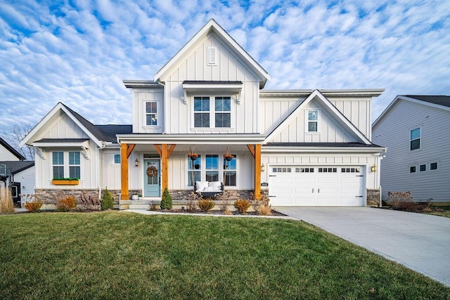 view of front of property with a front yard, a garage, and covered porch