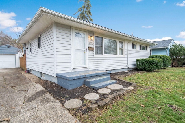 view of front of home featuring a garage, an outbuilding, and a front yard