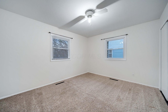 carpeted empty room featuring ceiling fan