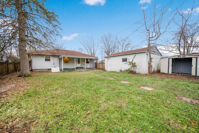 rear view of property featuring a lawn, a porch, and a storage unit