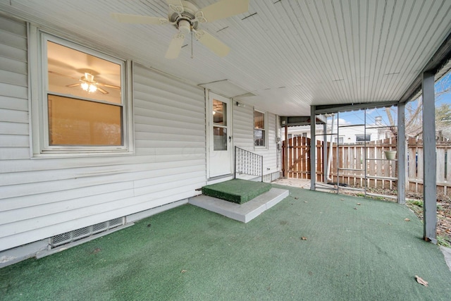 unfurnished sunroom featuring ceiling fan