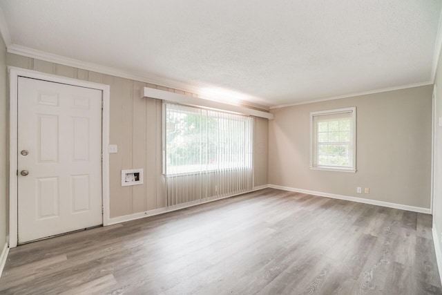 foyer with a textured ceiling, light wood-type flooring, and crown molding