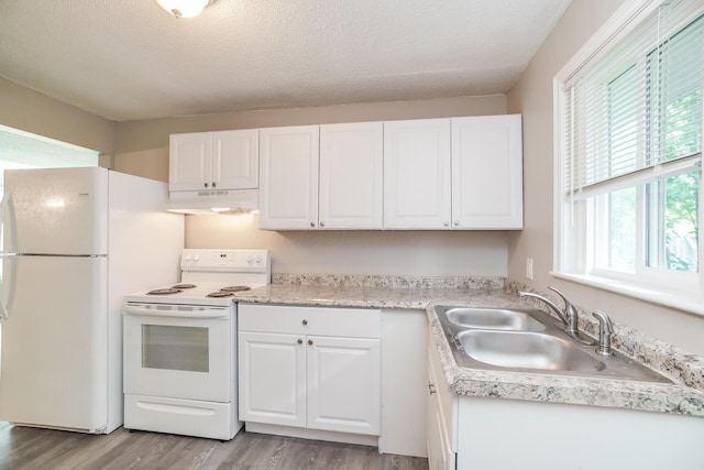 kitchen featuring white cabinetry, sink, a textured ceiling, white appliances, and light wood-type flooring