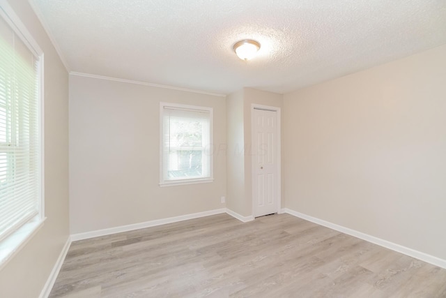 empty room featuring light hardwood / wood-style flooring and a textured ceiling