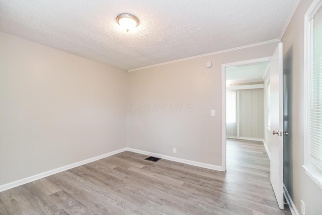 unfurnished room featuring a textured ceiling, light hardwood / wood-style floors, and crown molding