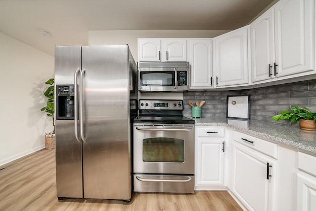 kitchen featuring stainless steel appliances, light stone counters, light hardwood / wood-style floors, decorative backsplash, and white cabinets