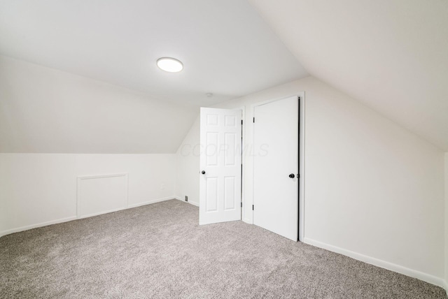 additional living space with carpet flooring and lofted ceiling