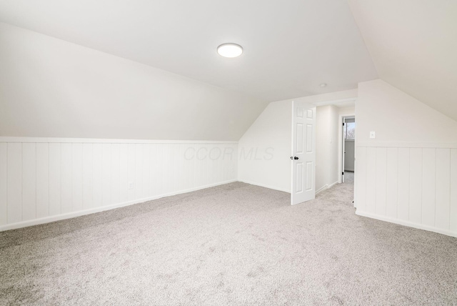 bonus room featuring light carpet and vaulted ceiling