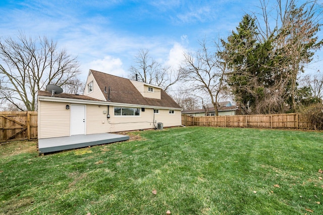 rear view of house featuring a deck and a lawn