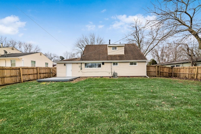 rear view of property with central AC unit and a lawn