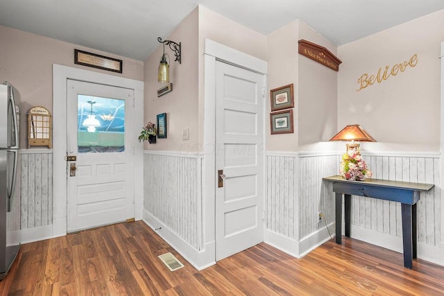 entrance foyer with hardwood / wood-style flooring and wooden walls