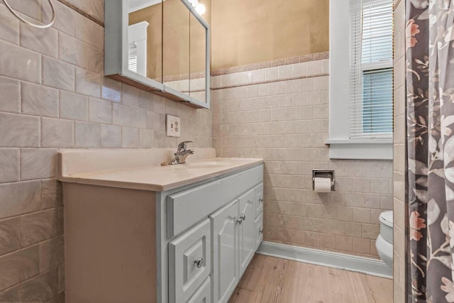 bathroom featuring vanity, hardwood / wood-style flooring, toilet, and tile walls