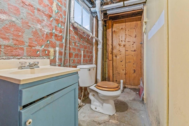 bathroom with vanity, toilet, and concrete flooring