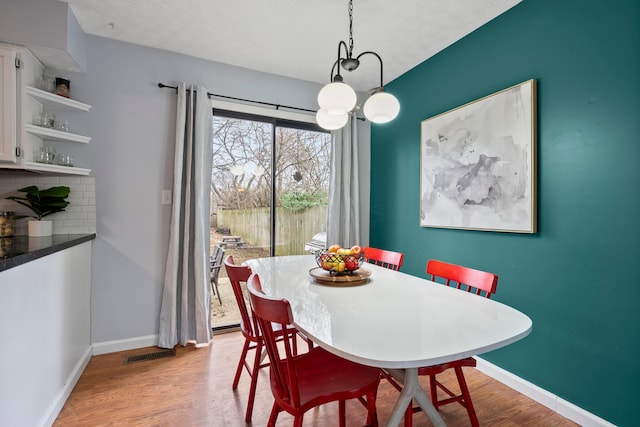 dining room with a textured ceiling and light hardwood / wood-style floors