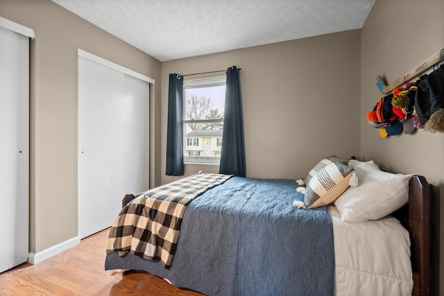 bedroom featuring light wood-type flooring and a textured ceiling