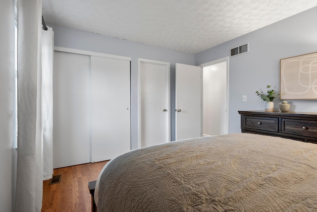 bedroom featuring a textured ceiling and hardwood / wood-style floors