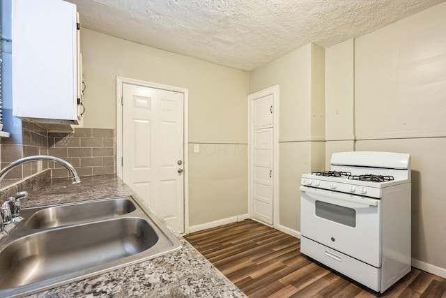 kitchen featuring dark wood-type flooring, sink, white range with gas stovetop, and a textured ceiling