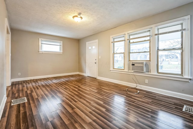 foyer entrance featuring cooling unit, dark hardwood / wood-style flooring, and a textured ceiling