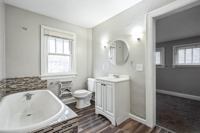 bathroom featuring hardwood / wood-style flooring, plenty of natural light, toilet, and vanity