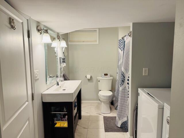 bathroom with tile patterned floors, vanity, toilet, and independent washer and dryer