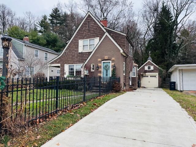 view of front of house with an outbuilding, a front lawn, and a garage