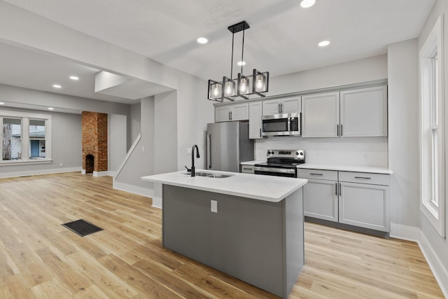 kitchen featuring gray cabinetry, a healthy amount of sunlight, sink, and stainless steel appliances