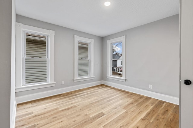 spare room featuring light hardwood / wood-style floors and a textured ceiling