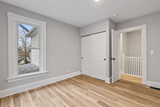 unfurnished bedroom featuring light wood-type flooring and a closet