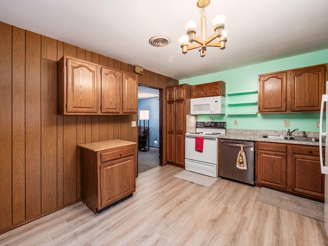 kitchen featuring sink, decorative light fixtures, a chandelier, light hardwood / wood-style flooring, and white appliances