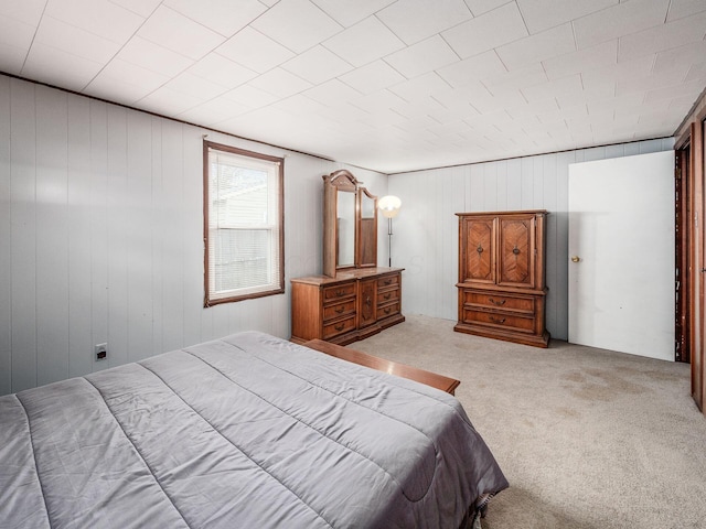 carpeted bedroom featuring wood walls