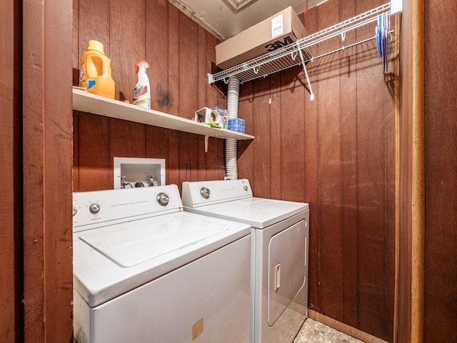 washroom featuring wooden walls and independent washer and dryer