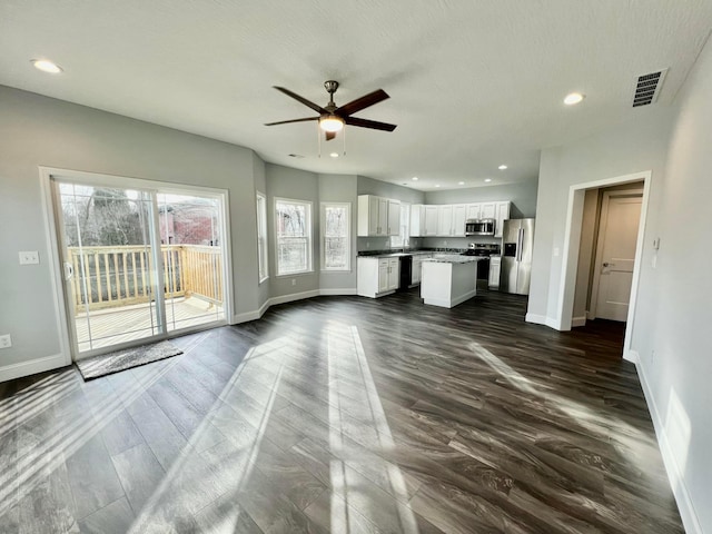 unfurnished living room with dark hardwood / wood-style floors and ceiling fan