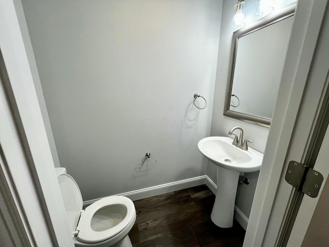 bathroom featuring wood-type flooring, toilet, and sink