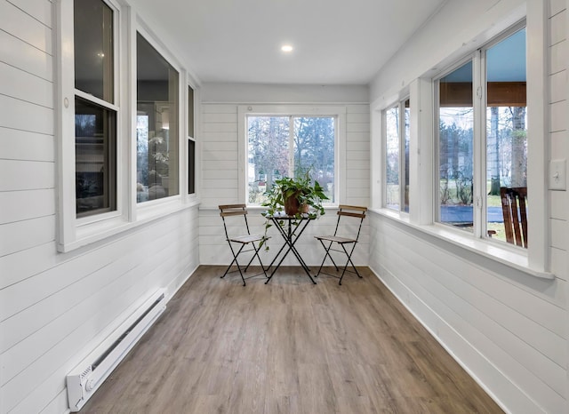 unfurnished sunroom featuring a baseboard radiator and plenty of natural light