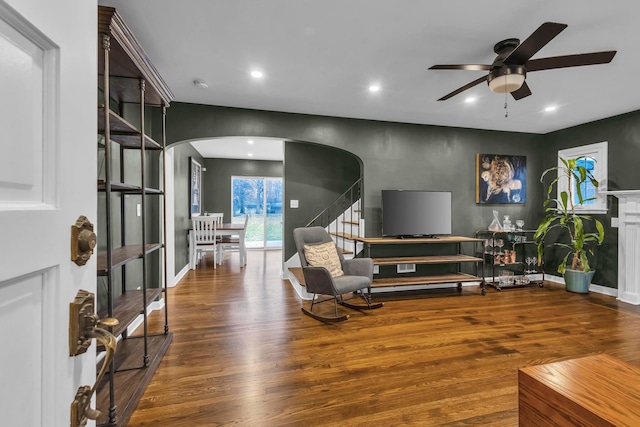 living room with ceiling fan and dark wood-type flooring