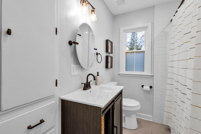 bathroom with curtained shower, vanity, wood-type flooring, and toilet