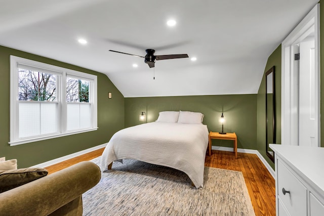 bedroom with ceiling fan, light hardwood / wood-style flooring, and vaulted ceiling