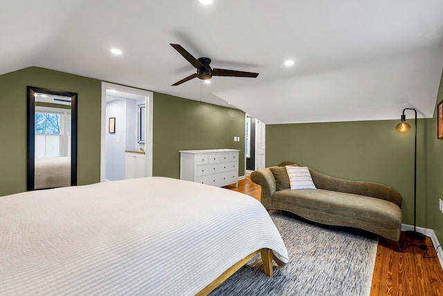 bedroom with connected bathroom, hardwood / wood-style flooring, vaulted ceiling, and ceiling fan