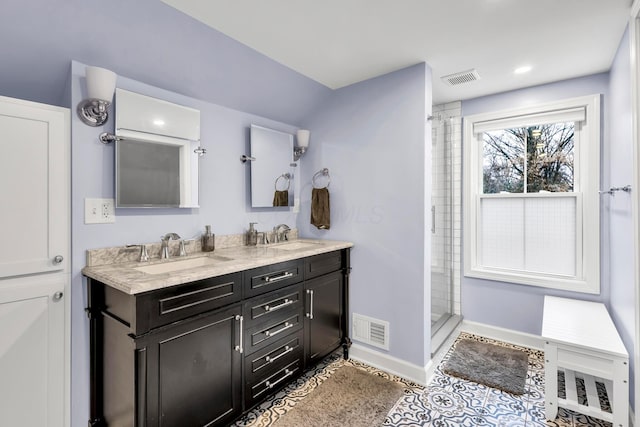 bathroom with tile patterned floors, vanity, and a tile shower