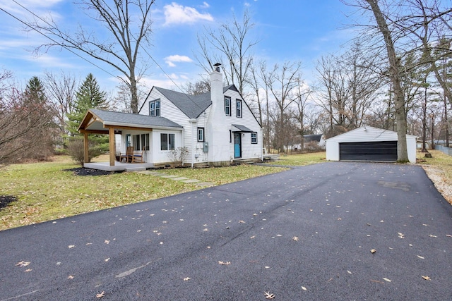 view of front facade with an outbuilding, a garage, and a front yard