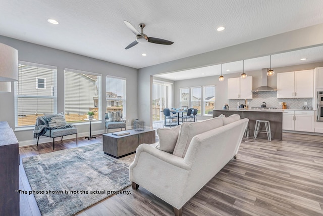 living room featuring hardwood / wood-style flooring, ceiling fan, and a healthy amount of sunlight