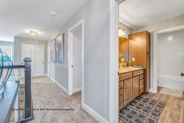 interior space with light hardwood / wood-style flooring, a textured ceiling, and sink