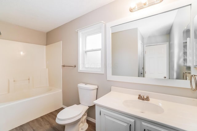 full bathroom featuring hardwood / wood-style flooring, vanity, shower / bathtub combination, and toilet