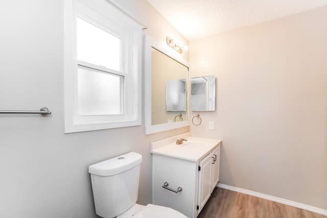 bathroom featuring hardwood / wood-style flooring, vanity, toilet, and a textured ceiling